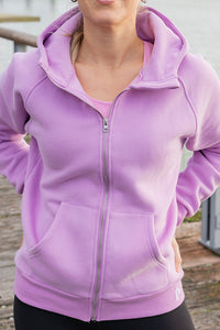 Person wearing a purple hoodie outdoors on a wooden deck